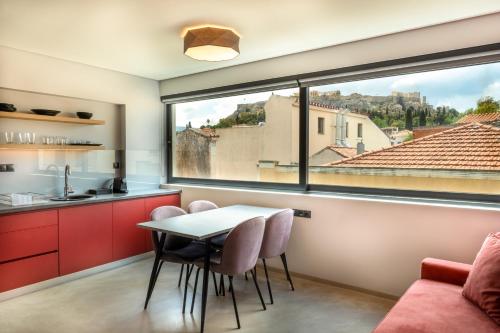 a kitchen with a table and chairs and a large window at Muse Urban Suites in Athens