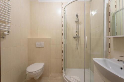 a bathroom with a shower and a toilet and a sink at Apartament Regina Maris in Świnoujście