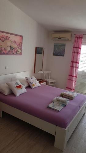 a bedroom with a large bed with purple sheets at Apartments Boćin Rosso in Hvar