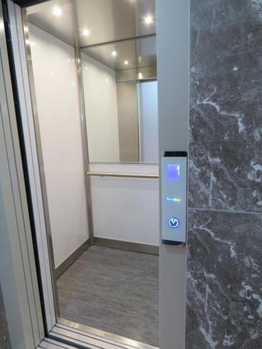 a bathroom with a glass door with a mirror at Aquamarine Sea Front Apartments - First Floor in Marsaskala