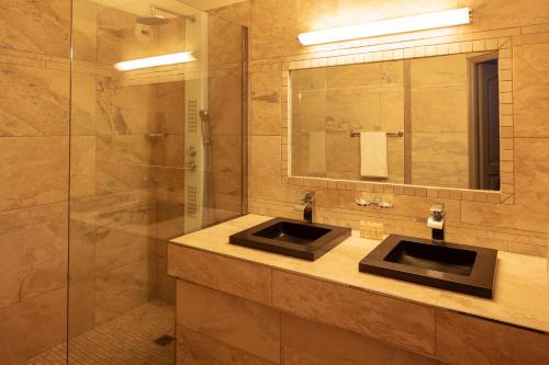 a bathroom with two sinks and a mirror at Hotel Le Ruesco in Olmeto