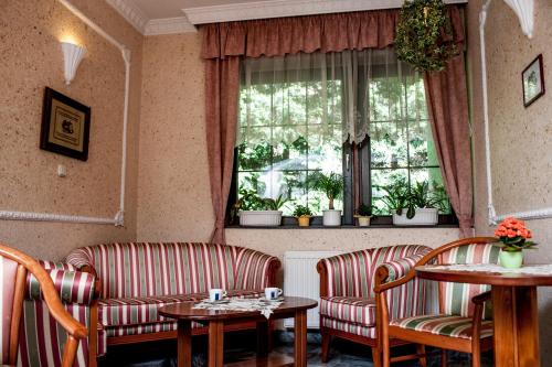 a living room with two chairs and tables and a window at Beatrix Hotel in Budapest