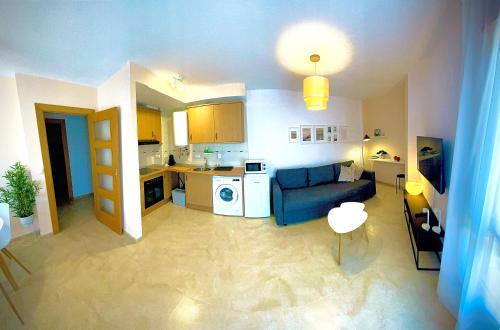 a living room with a blue couch and a kitchen at Ideal Apartamento - Guadalest in Guadalest