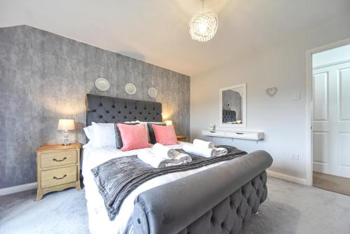 ein Schlafzimmer mit einem großen Bett mit roten Kissen in der Unterkunft Belle Cottage in Ashbourne