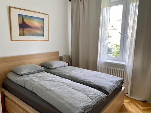 ein Bett in einem Schlafzimmer mit einem Fenster in der Unterkunft Chic Apartment in vibrant area - National Stadium - Saska Kępa in Warschau