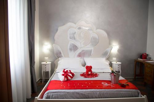 a bed with a red blanket and a teddy bear on it at Il Teatro B&B in Marina di Gioiosa Ionica