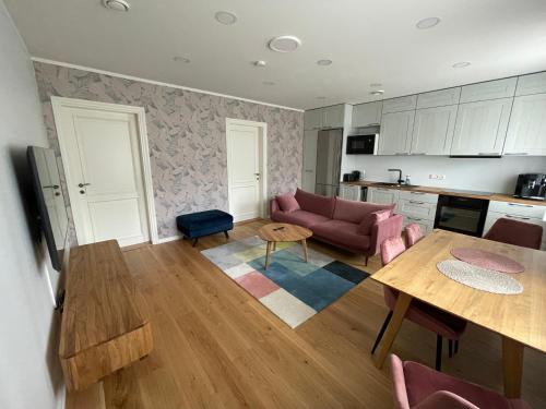 a living room with a pink couch and a table at Niidupuu Apartment in Kuressaare