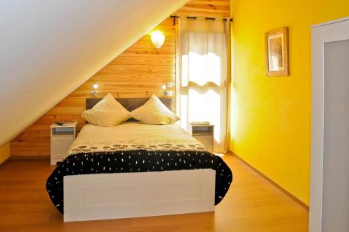 een slaapkamer met een bed in een kamer met gele muren bij La cabane du bonheur, un gite écologique 
