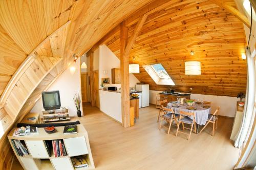 een keuken en een woonkamer met een houten plafond bij La cabane du bonheur, un gite écologique 