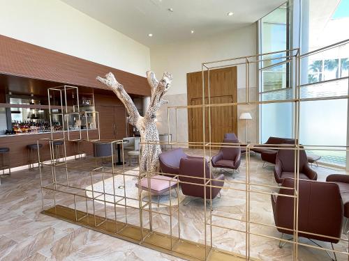 a lobby with a tree in the middle at UNA HOTELS MH Matera in Matera