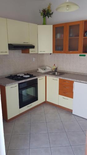 a kitchen with white cabinets and a stove top oven at Apartments Boćin Rosso in Hvar