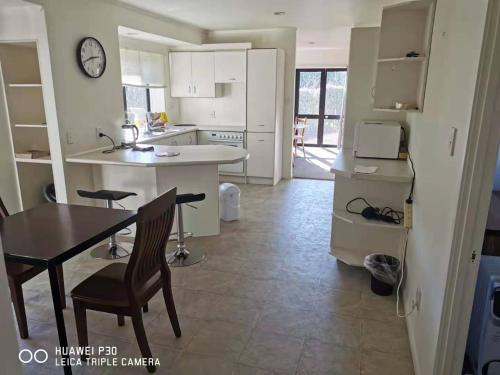 uma cozinha com uma mesa e uma mesa e cadeiras em Red Brick House em Auckland