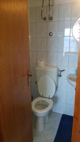 a bathroom with a white toilet and a sink at Apartments Boćin Rosso in Hvar