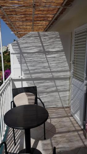 a chair and a table on a balcony at Apartments Boćin Rosso in Hvar