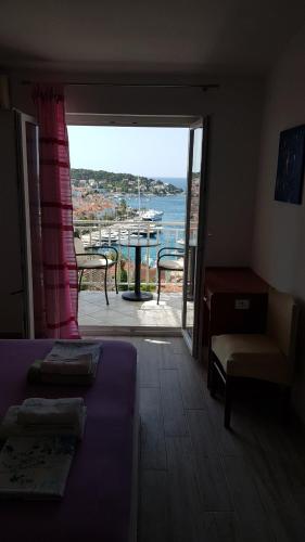 a room with a bed and a view of the ocean at Apartments Boćin Rosso in Hvar