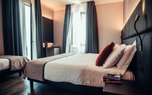 a hotel room with a large bed and a window at Hotel Benaco in Desenzano del Garda