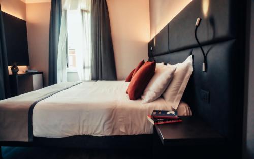 a bedroom with a large bed with red pillows at Hotel Benaco in Desenzano del Garda