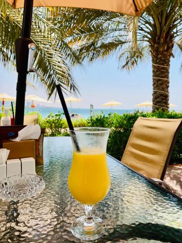 a glass of orange juice sitting on top of a table at Luxurious Studio Pacific Al Marjan Island - beachfront property in Ras al Khaimah