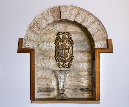 a clock on a wall with a wine glass at Gioraldi Art Hotel in Ano Pedina