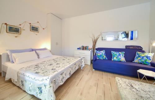 a bedroom with a bed and a blue couch at Apartment Nena in Krk