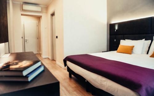 a bedroom with a bed and a table with books at Hotel Benaco in Desenzano del Garda