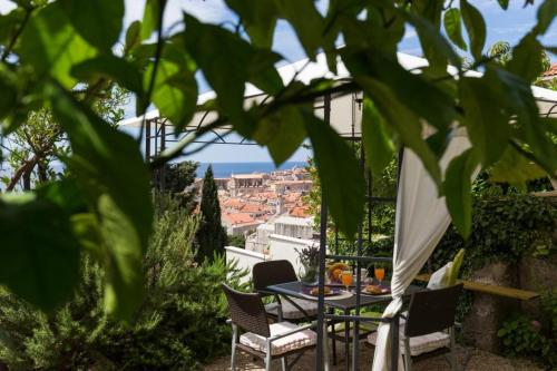 uma mesa e cadeiras numa varanda com vista para o oceano em Apartment Purple Rain em Dubrovnik