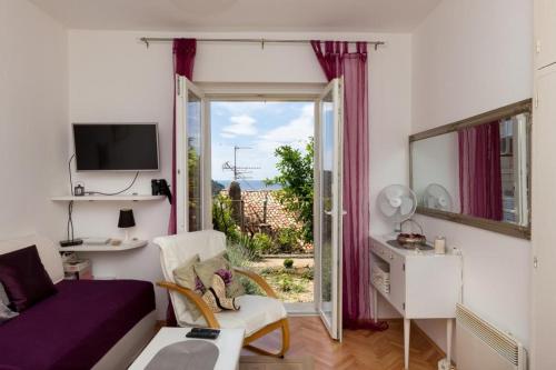 - un salon avec un lit et une porte coulissante en verre dans l'établissement Apartment Purple Rain, à Dubrovnik