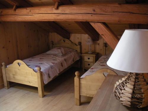 a bedroom with two beds and a table with a lamp at Chalet L' Irrawaddy in Megève