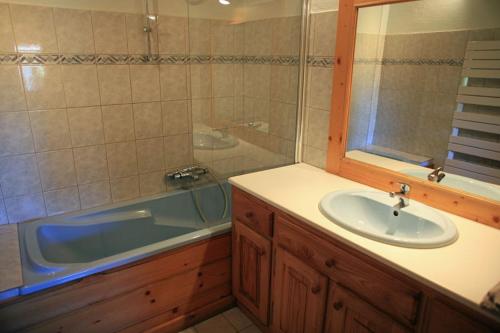 une salle de bain avec un lavabo et une baignoire et un lavabo dans l'établissement Chalet L' Irrawaddy, à Megève