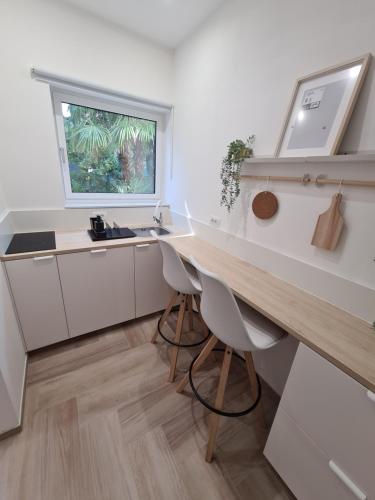 a kitchen with a desk and a sink and a window at Balance apartments in Koper