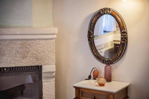 a mirror sitting on a table next to a fireplace at Gioraldi Art Hotel in Ano Pedina