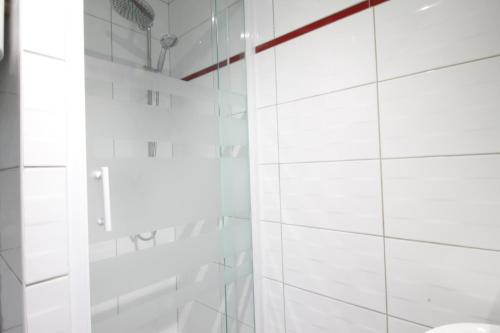 een wit betegelde badkamer met een glazen douchecabine bij Tramway 10 JAURES Cosy proche gare in Le Mans