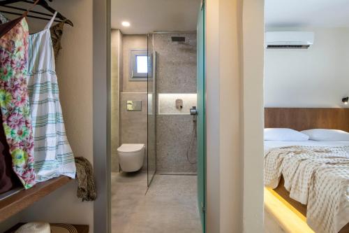 1 dormitorio con 1 cama y baño con ducha. en Ammos Kalamitsi, en Kalamitsi