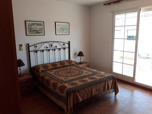 een slaapkamer met een bed en een groot raam bij Casa Angelus in Águilas