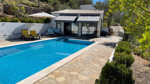 a swimming pool in front of a house at B&B Casa Encantada in Boliqueime