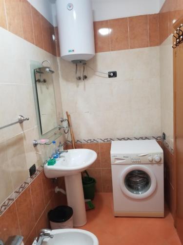 La salle de bains est pourvue d'un lave-linge et d'un lavabo. dans l'établissement Dea Apartment, à Durrës