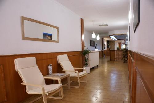 a corridor of a waiting room with chairs and a counter at Mesón Kubano B&B in Sant Mateu
