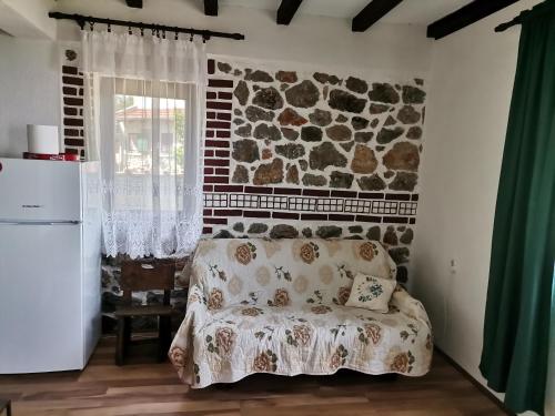 sypialnia z łóżkiem i kamienną ścianą w obiekcie Villa Sofia w Ochrydzie
