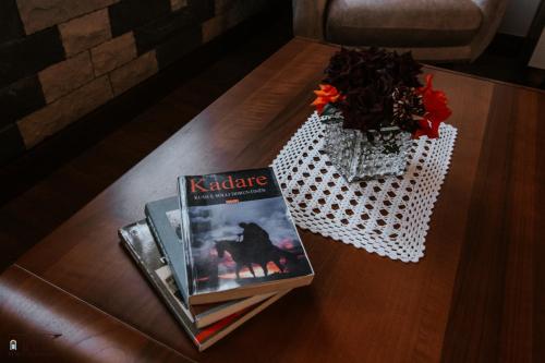 a table with a book and a vase of flowers at KERCULLA Resort in Gjirokastër