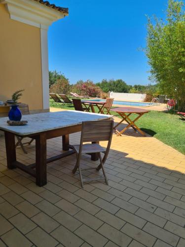 a picnic table and a bench on a patio at Casa dos Ventos in Olhão