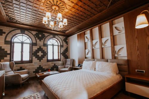 a bedroom with a bed and chairs in a room at KERCULLA Resort in Gjirokastër