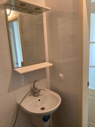 ein Bad mit einem Waschbecken und einem Spiegel in der Unterkunft Cozy House on Vanceti Street in Odessa