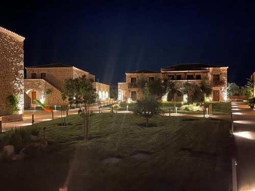 a building with a lawn in front of it at night at Mystras Grand Palace Resort & Spa in Mystras