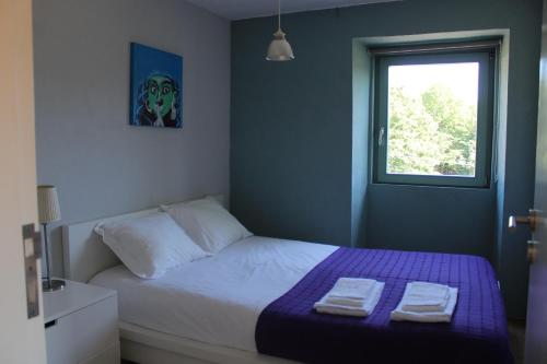 a bedroom with a bed with two towels on it at Lugar da Lourida in Caminha