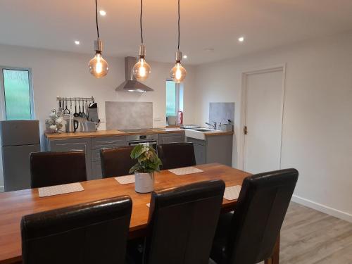 a kitchen with a wooden table and black chairs at Fairwater Head in Axminster