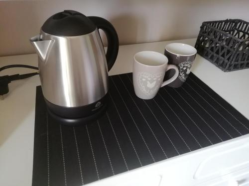 a coffee maker and two cups on a counter at Chambres en chalet petit déjeuner inclus in La Côte dʼArbroz