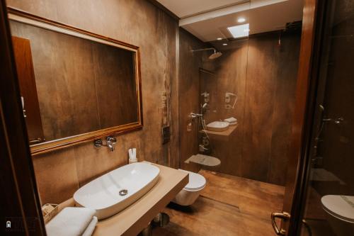 a bathroom with a tub and a toilet and a sink at KERCULLA Resort in Gjirokastër