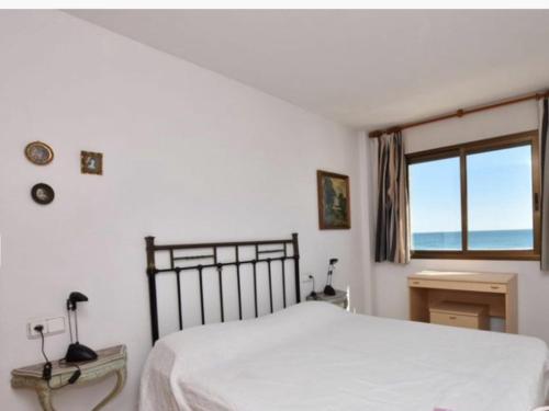 a bedroom with a white bed and a window at Gaia in Torredembarra