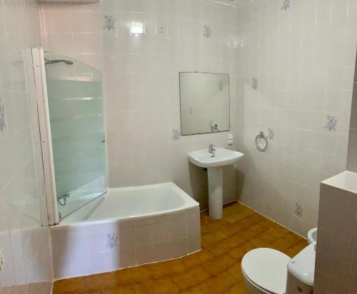 a bathroom with a tub and a sink and a toilet at Mesón Kubano B&B in Sant Mateu