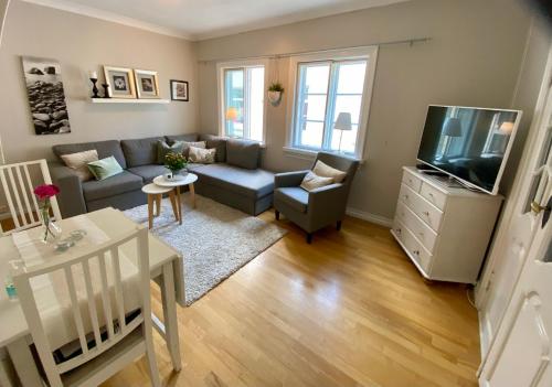 een woonkamer met een bank en een tv bij Lille Øvregate in Bergen
